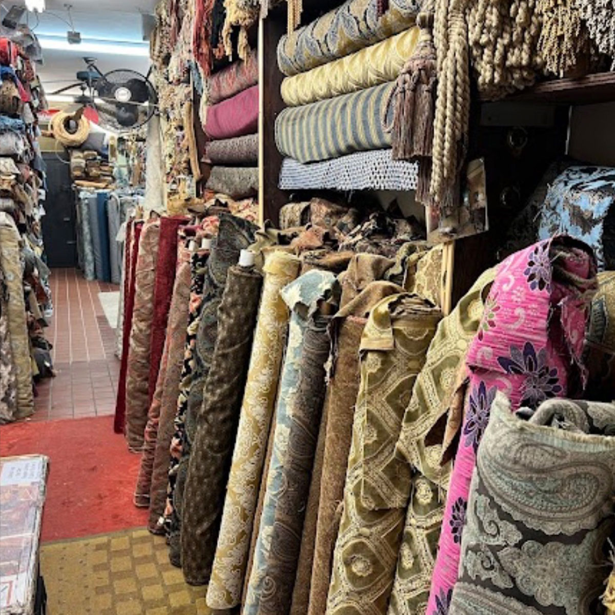 Upholstery fabric rolls and decorative trim displayed inside Fabric City