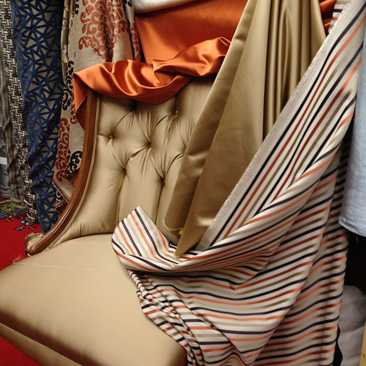 Tufted chair surrounded by patterned and solid upholstery fabrics